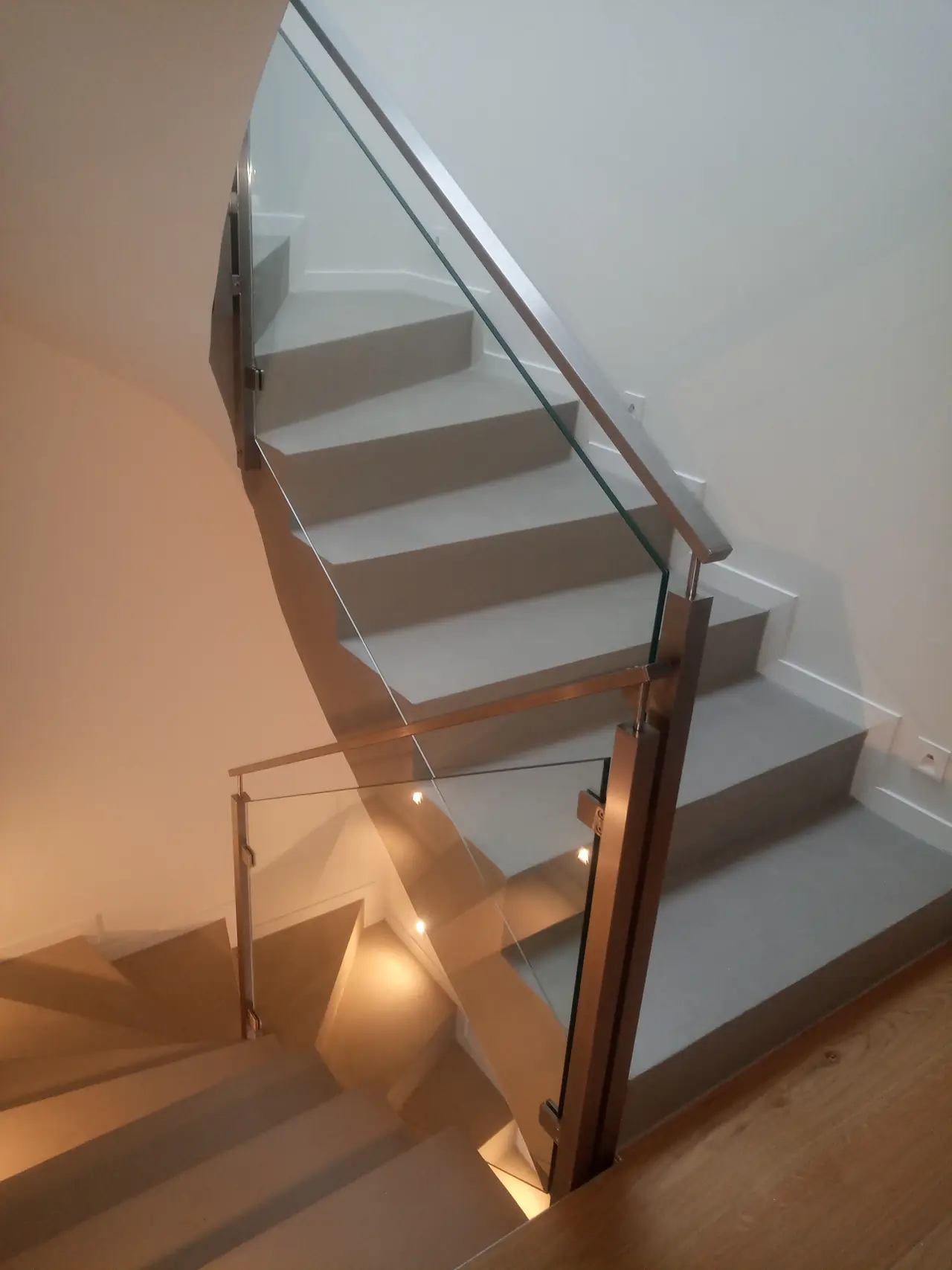 Escalier hélicoïdal avec garde-corps en verre et main courante