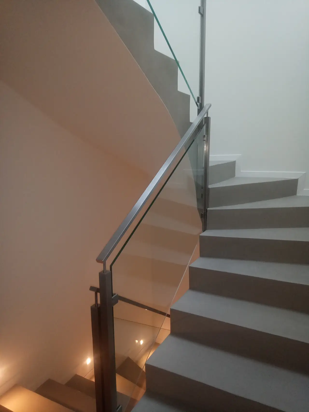 Vue montante d'un escalier hélicoïdal avec garde-corps en verre
